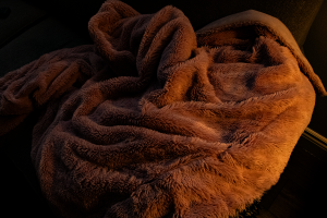 A loose blanket in low, orange lighting.