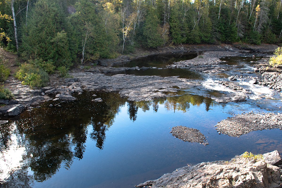 Image of a river in Thunder Bay's Centennial Park and the reflection in the water.